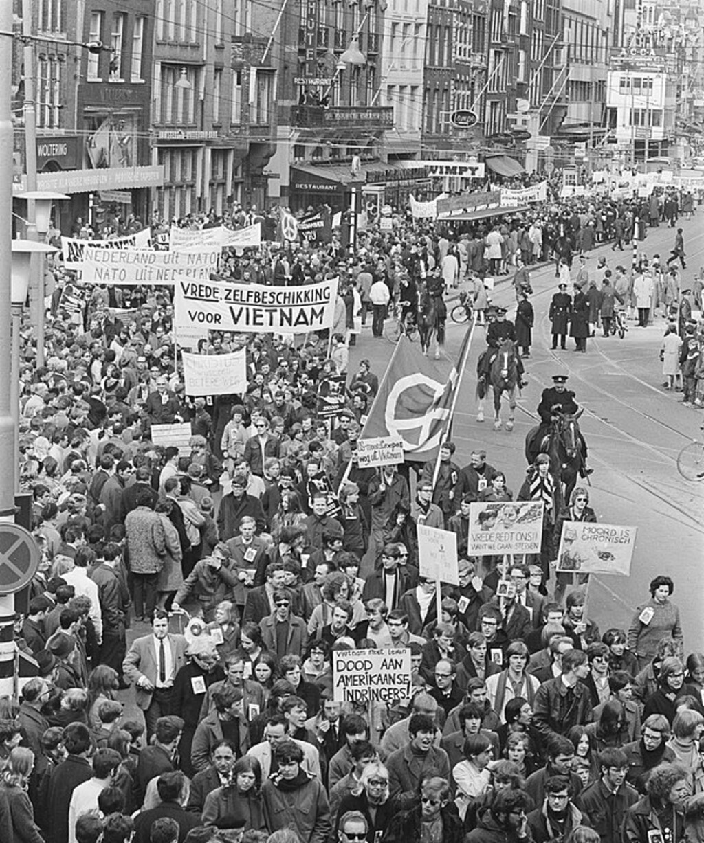 Foto: studentenprotest <a href="https://en.wikipedia.org/wiki/Protests_of_1968#/media/File:Demonstratie_tegen_oorlog_in_Vietnam,_NATO_enz._in_Amsterdam,_Bestanddeelnr_921-2506.jpg">wikipedia </a>commons Auteursnaam en licentie staan vermeld in de link. 
